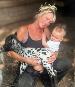 Lareen Steven's holding her grandson in her left arm & a foal in her right arm
